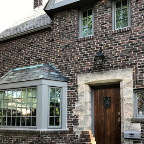 A Brick House with Tudor-Style Windows by HS Windows