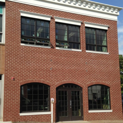 Brick commercial building with black-framed windows in Ridgewood by HS Windows.