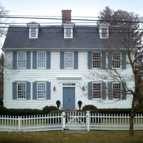 house with white picket fence and several windows in hohokus