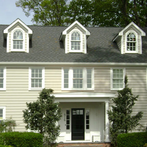 Classic beige colonial home with white windows in Ho-Ho-Kus by HS Windows.